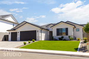Ranch-style house featuring stone siding, stucco siding, an attached garage, and decorative driveway