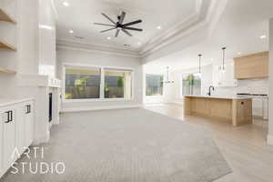 Unfurnished living room featuring ornamental molding, recessed lighting, a chandelier, a fireplace, and a ceiling fan