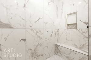 Full bathroom with a marble finish shower