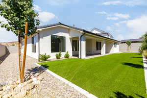 Back of house featuring a fenced backyard, a patio, and stucco siding