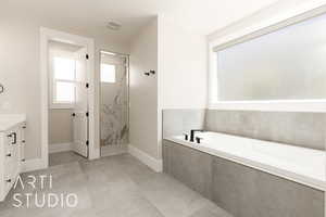 Full bathroom with a bath, vanity, and a marble finish shower