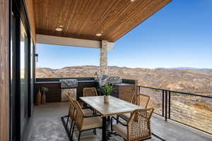 Balcony with outdoor dining space, a grill, and a mountain view