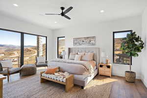 Bedroom featuring hardwood / wood-style flooring, recessed lighting, ceiling fan, access to exterior, and a mountain view