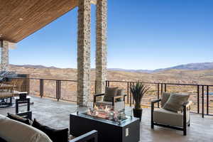 View of patio / terrace featuring a mountain view and an outdoor living space with a fire pit