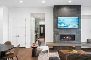 Living area with dark wood finished floors, recessed lighting, and a fireplace