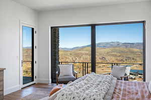 Bedroom featuring a mountain view, wood finished floors, and access to outside