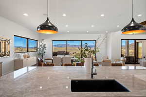 Kitchen featuring open floor plan, a mountain view, light stone countertops, decorative light fixtures, and recessed lighting