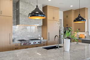 Kitchen with tasteful backsplash, pendant lighting, light stone countertops, stainless steel appliances, and recessed lighting