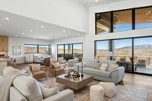 Living area with recessed lighting, light wood-style floors, a mountain view, and a high ceiling