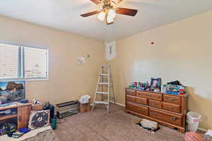 Interior space featuring carpet floors, ceiling fan, and a textured ceiling
