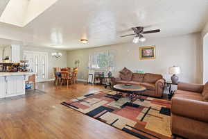Living area featuring a textured ceiling, wood finished floors, and a ceiling fan