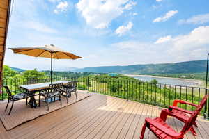 Deck featuring outdoor dining area and a water and mountain view
