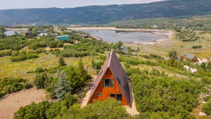 Aerial view of property and surrounding area featuring a water and mountain view