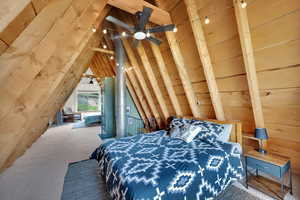 Bedroom featuring wooden walls and carpet floors