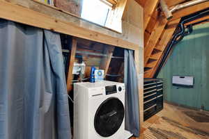Laundry area featuring washer / dryer, wood walls, and tile patterned floors
