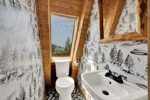 Bathroom featuring toilet and wallpapered walls