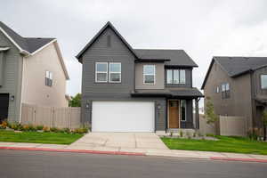View of front of property featuring an attached garage and concrete driveway