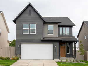 View of front of property featuring an attached garage and concrete driveway