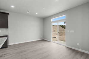 Unfurnished dining area with light wood-style flooring, recessed lighting, a fireplace, and a textured ceiling