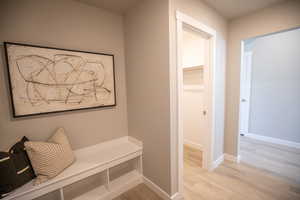 Mudroom featuring light wood-style floors and baseboards