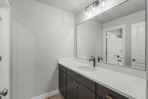 Bathroom with vanity, wood finished floors, and a textured ceiling