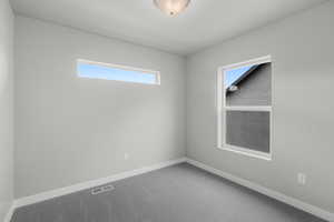 Carpeted empty room with baseboards