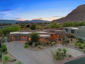 View of front of property featuring a mountain view, curved driveway, stucco siding, and an attached garage