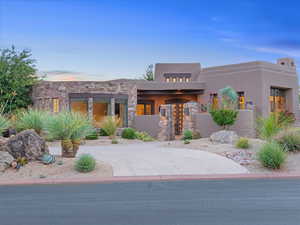 View of front of house featuring stone siding and stucco siding