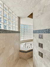 Full bathroom featuring tile walls and tile patterned flooring