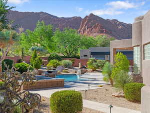 View of swimming pool with a mountain view, a pool with connected hot tub, and a patio area