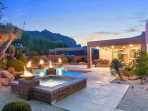 View of pool with a patio area, an outdoor bar, a pool with connected hot tub, area for grilling, and ceiling fan