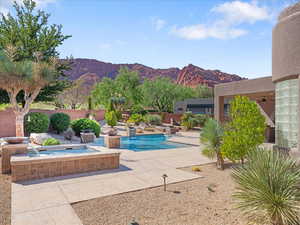 View of pool with a mountain view, a patio, and a pool with connected hot tub