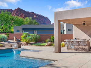 Outdoor pool with a patio area, a mountain view, and ceiling fan