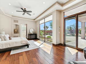 Bedroom with hardwood / wood-style flooring, a tray ceiling, access to outside, and recessed lighting