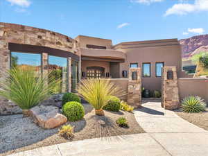 Pueblo revival-style home featuring a fenced front yard and stucco siding
