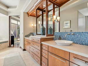 Full bath featuring vanity, backsplash, and recessed lighting