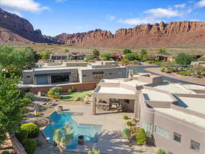 Rear view of property with a mountain view, stucco siding, a patio, an outdoor pool, and a gazebo
