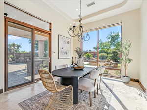 Dining room featuring a chandelier, a tray ceiling, healthy amount of natural light, and recessed lighting