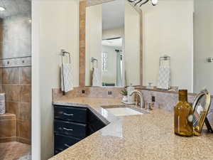 Full bath with vanity and tasteful backsplash