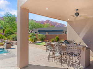 View of patio with a mountain view and ceiling fan