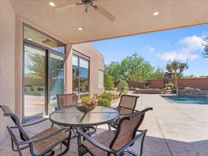 Fenced backyard featuring a patio area, ceiling fan, and outdoor dining area