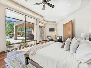 Bedroom with a tray ceiling, hardwood / wood-style floors, and recessed lighting