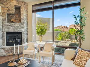 Sitting room with wood finished floors and a stone fireplace