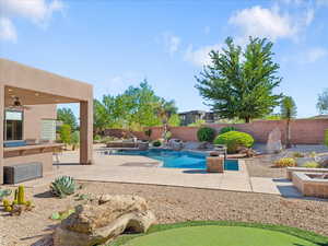 View of swimming pool featuring a patio area, a fenced backyard, and a ceiling fan