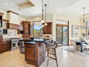 Kitchen featuring tasteful backsplash, double oven range, a chandelier, recessed lighting, and beverage cooler