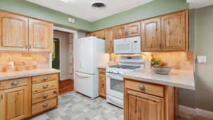 Kitchen with backsplash, under cabinet lighting, and gas stove