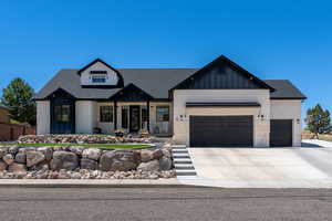 Modern inspired farmhouse featuring a garage, driveway, roof with shingles, and board and batten siding