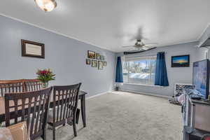 Dining room featuring crown molding, carpet, and a ceiling fan