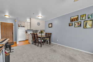 Dining space featuring baseboards and light colored carpet