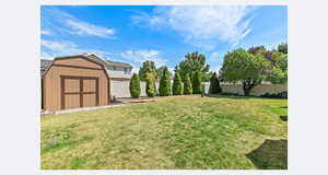 Fenced backyard with a large storage shed